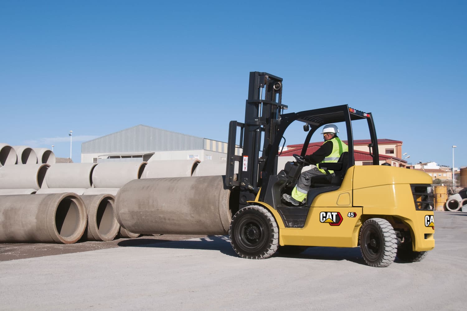 CAT DP45N diesel forklift handling concrete pipe at a job site